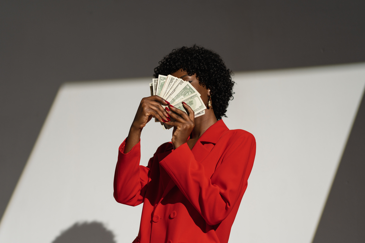 Woman in Red Suit Hiding Her Face with Money